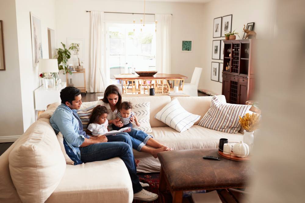 Happy family relaxing in a bright, energy-efficient home with natural ventilation and comfortable indoor temperature