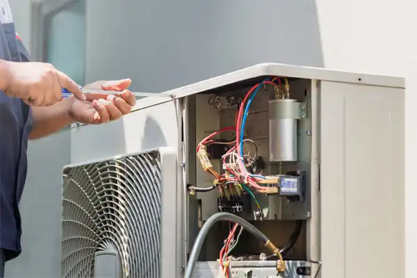 Technician servicing an outdoor HVAC unit