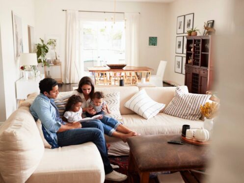 Happy family relaxing in a bright, energy-efficient home with natural ventilation and comfortable indoor temperature
